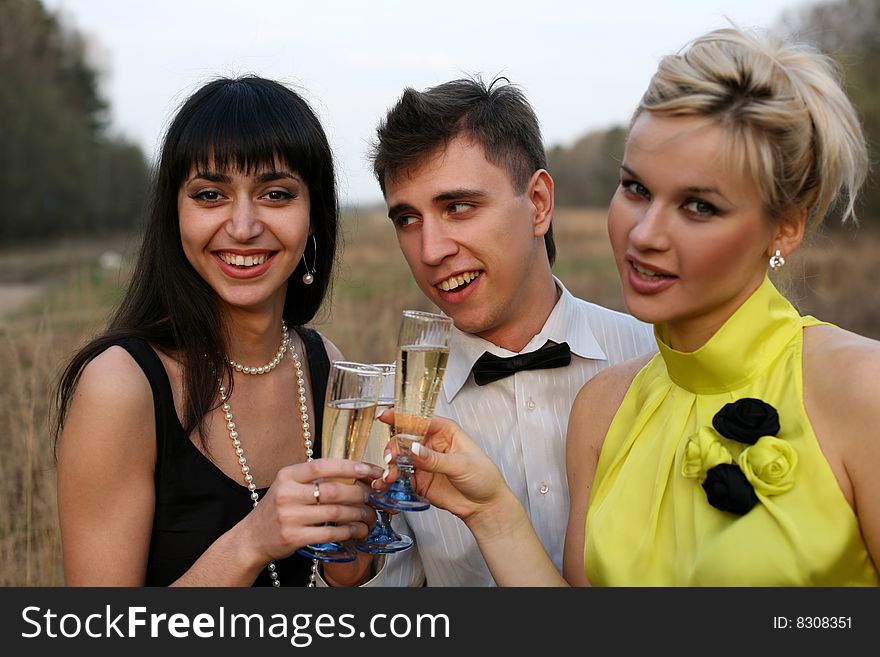 Two girls and man with wine outdoors. Two girls and man with wine outdoors