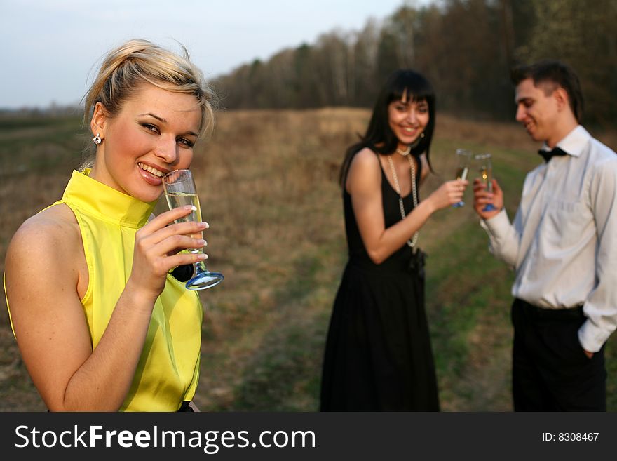 Two girl and man with wine outdoors. Two girl and man with wine outdoors