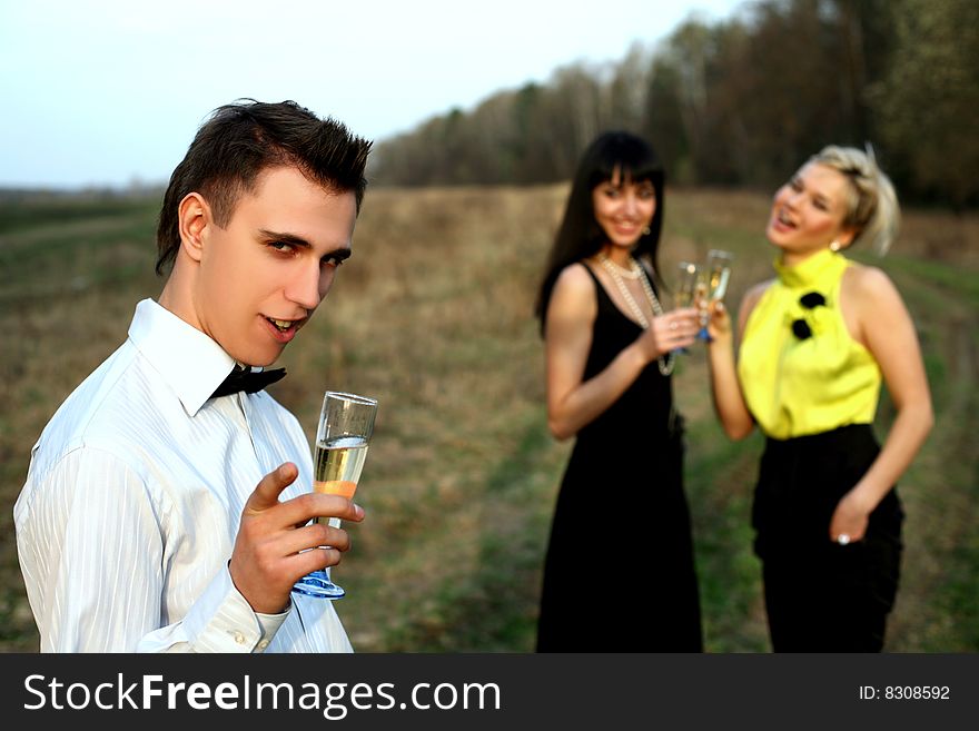 Two girl and man with wine outdoors. Two girl and man with wine outdoors