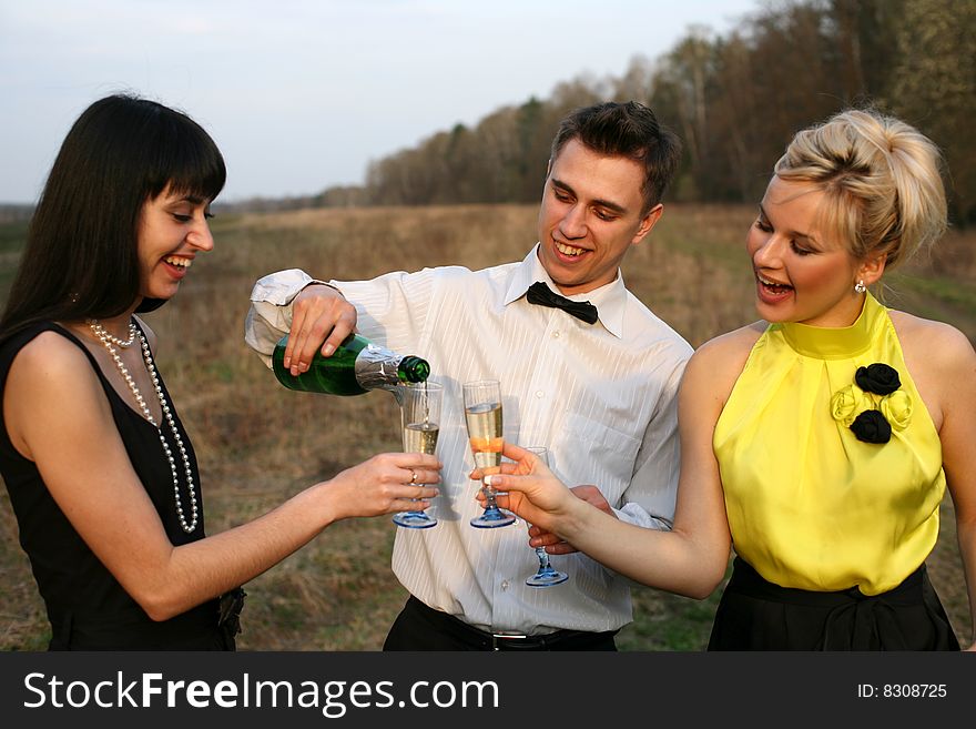 Two girl and man with wine outdoors. Two girl and man with wine outdoors