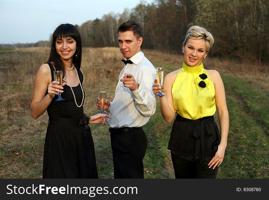Two girl and man with wine outdoors. Two girl and man with wine outdoors