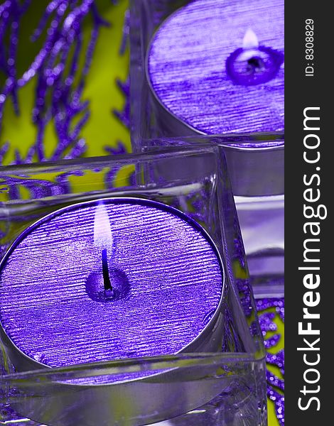 Violet candles in glass with water