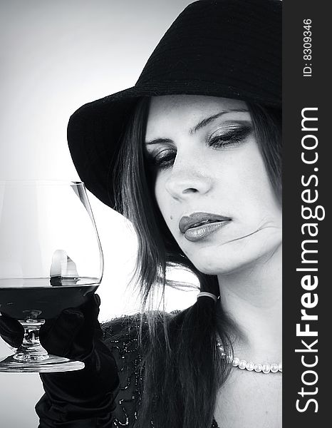 Portrait of the beautiful brunette with a cognac glass
