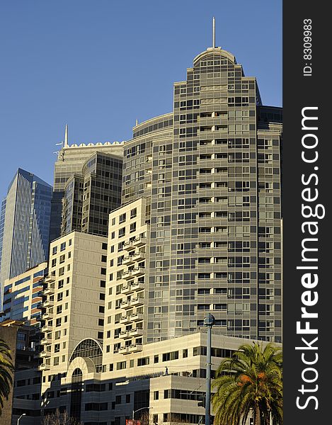 Cluster of modern highrise buildings.  Metaphor or symbol for competition in the workplace. Clear blue sky. Cluster of modern highrise buildings.  Metaphor or symbol for competition in the workplace. Clear blue sky.