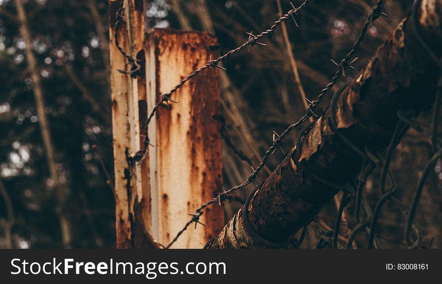 Close up of barbed wire fencing on worn wooden post outdoors. Close up of barbed wire fencing on worn wooden post outdoors.