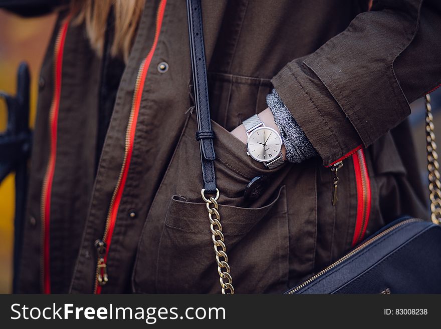 Woman Brown Coat Wearing Silver Analog Watch While Hand In Her Pocket