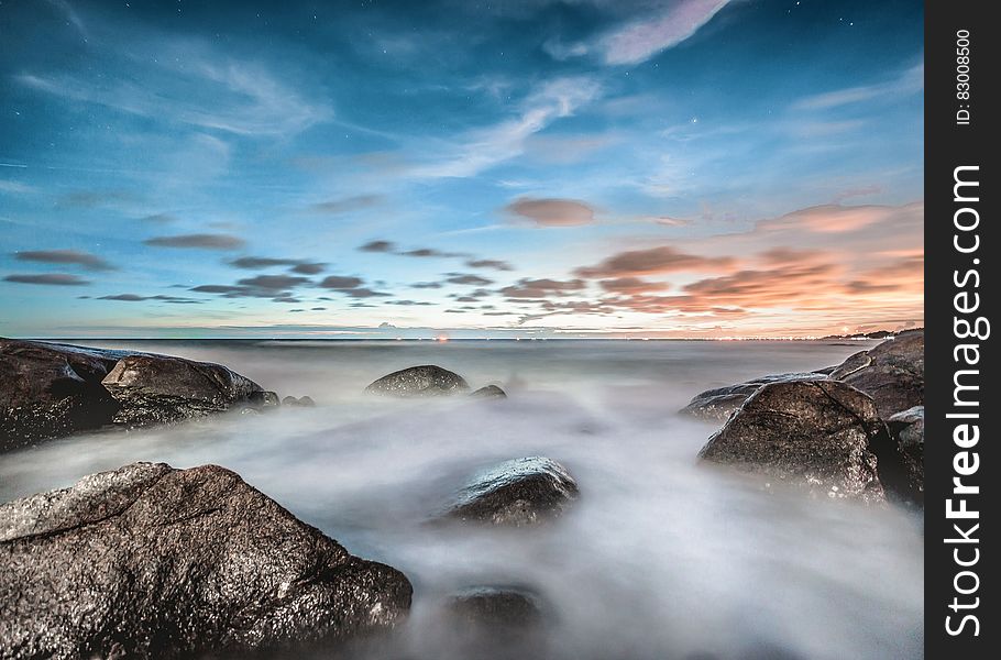 Blur of water creating fog over rocky coastline at sunrise. Blur of water creating fog over rocky coastline at sunrise.