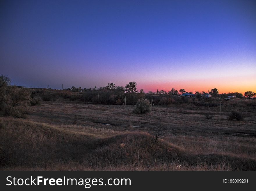 Sunset over rural fields with blue skies. Sunset over rural fields with blue skies.