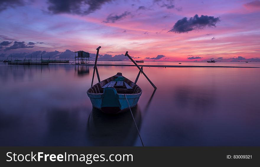 Wooden boat in calm waters at sunset. Wooden boat in calm waters at sunset.