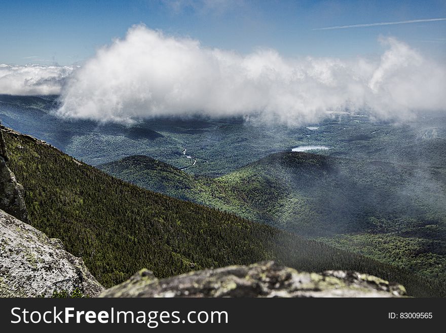 A view of mountain slopes covered in thick forest from the mountain top. A view of mountain slopes covered in thick forest from the mountain top.