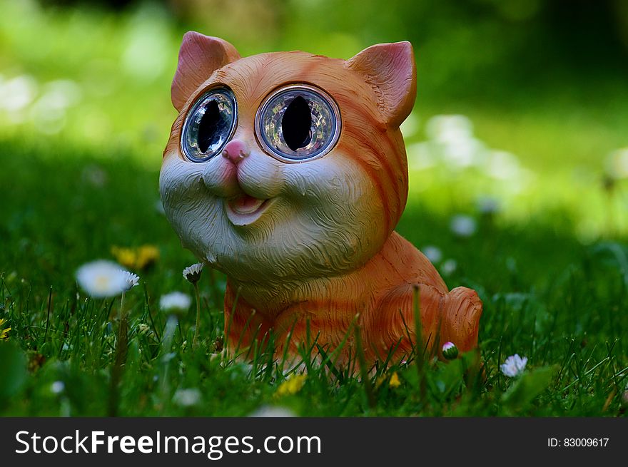 Yellow and Orange Tabby Kitten Figurine on Green Grass Plant