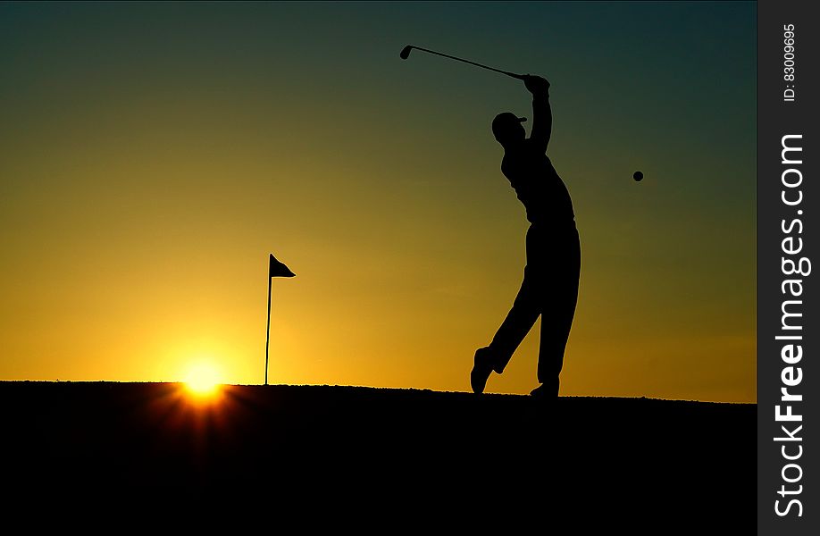 Silhouette of Man Playing Golf during Sunset