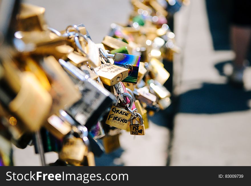 Locks of love on urban bridge on sunny day.