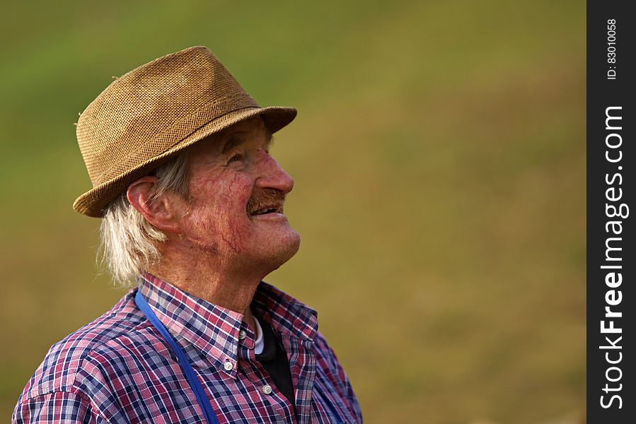 A farmer with a trilby hat and plaid shirt.