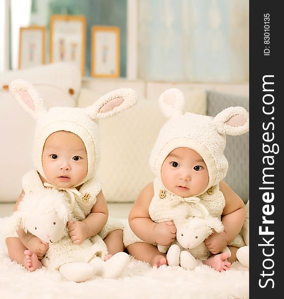 2 Babies Wearing White Headdress White Holding White Plush Toys