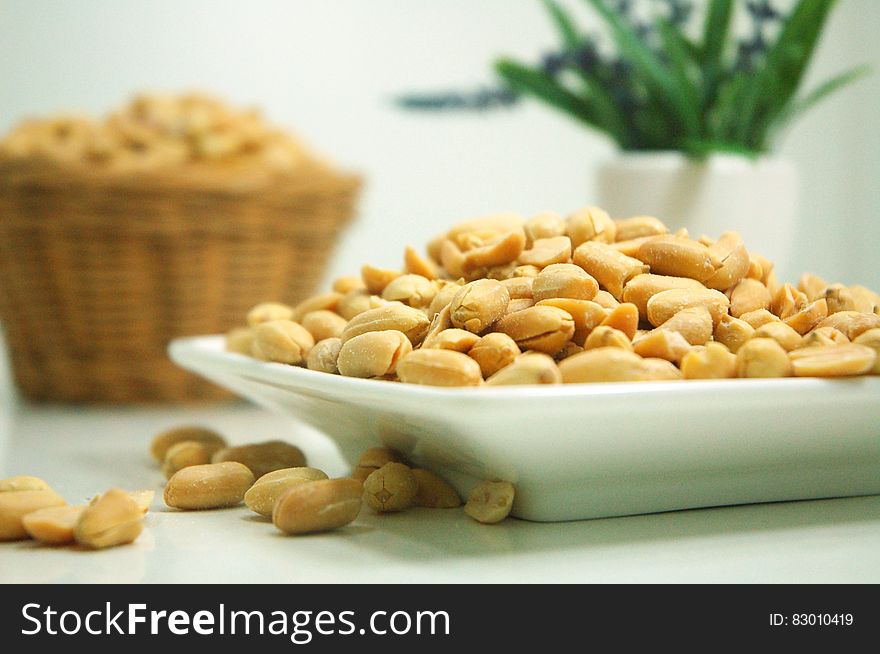 White china plate with shelled peanuts. White china plate with shelled peanuts.