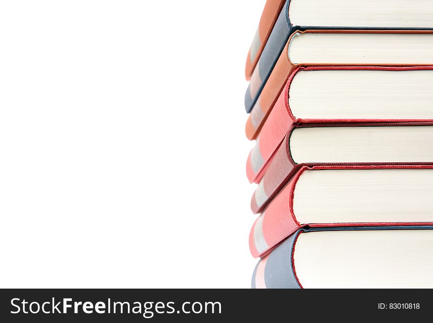 Tall pile of books with white paper (pages) and red and blue bindings, arranged to leave blank space for added text or advertising.