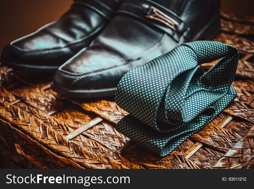 Man&#x27;s Black Leather Shoes Near to Green and White Spotted Tie