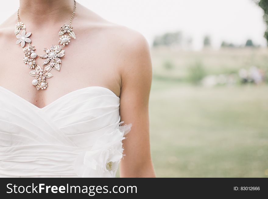 Woman in White Dress Wearing Gold Chunky Necklace during Daytime