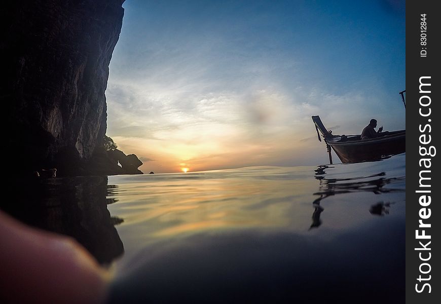 Silhouette Of Man Riding Boat