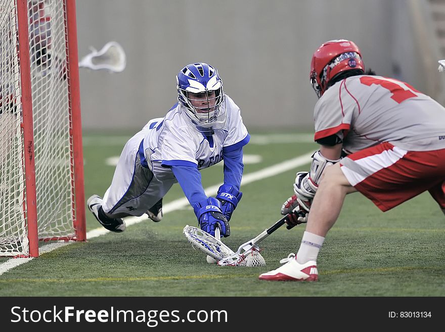 Person Wearing Blue Gloves Holding Lacrosse Stick