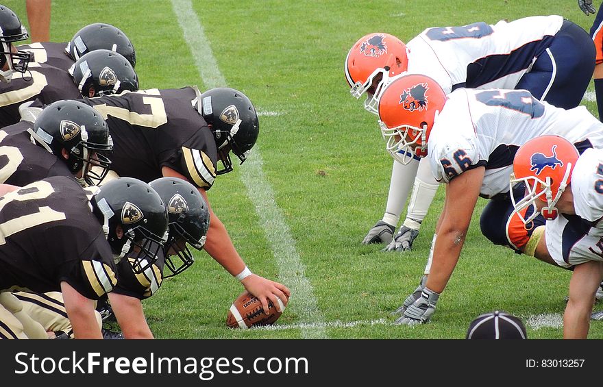 Two American football teams facing off at snap on the field. Two American football teams facing off at snap on the field.