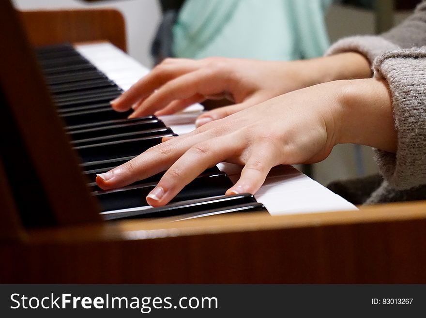 A piano player's hands on the piano keys.