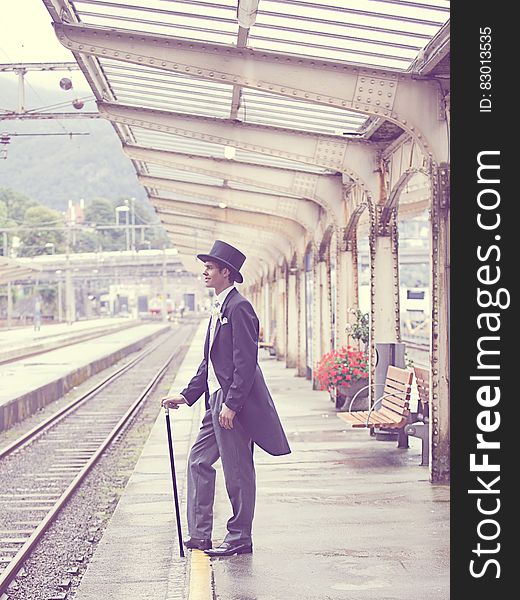 Sepia Effects Photo of Man in Black Tuxedo Standing on Train Station during Daytime