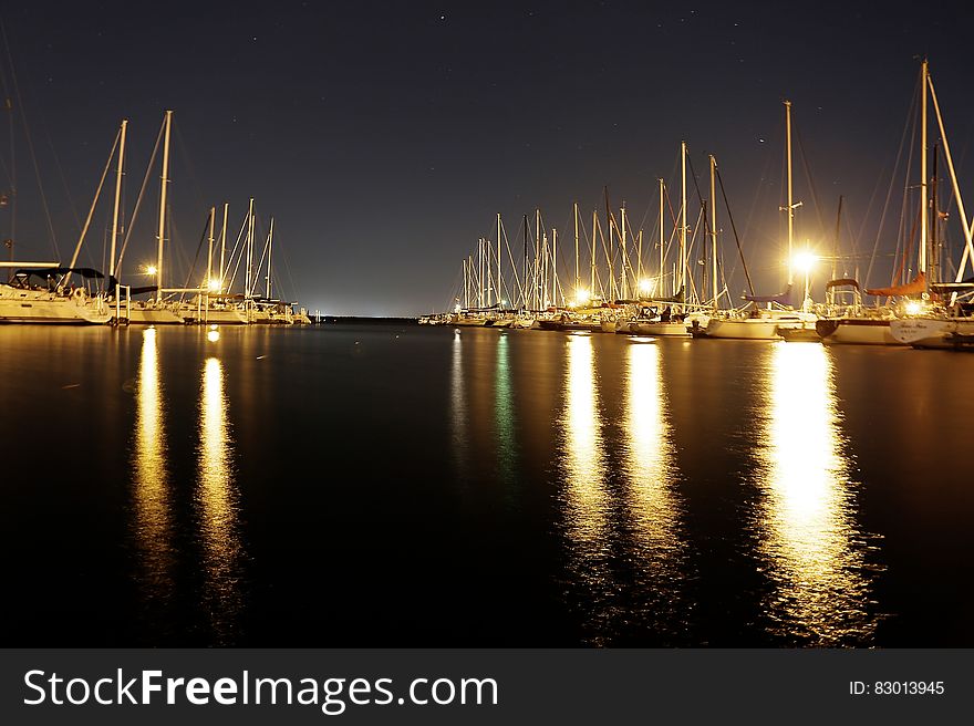 Sailboats illuminated in harbor