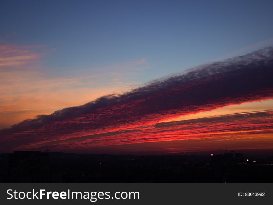 Sunset in cloudy skies over horizon.