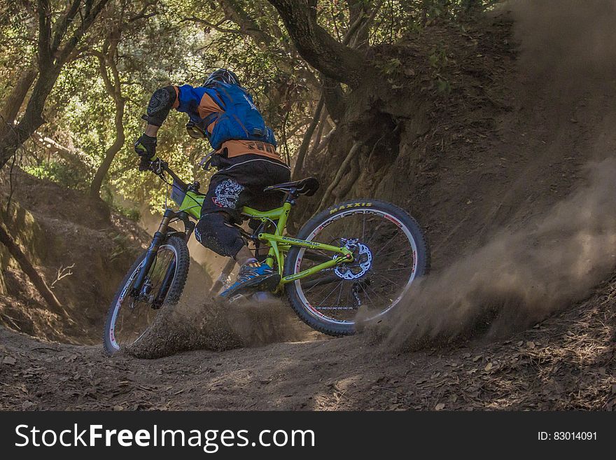 Man in Black and Orange Bicycle Riding Jacket With Green Off Road Bike