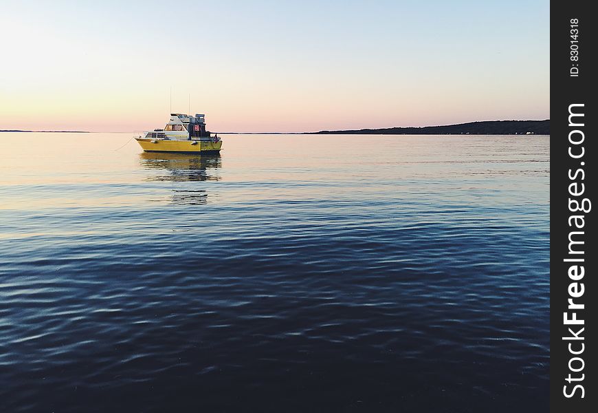 Boat on waters reflecting sunset on horizon. Boat on waters reflecting sunset on horizon.