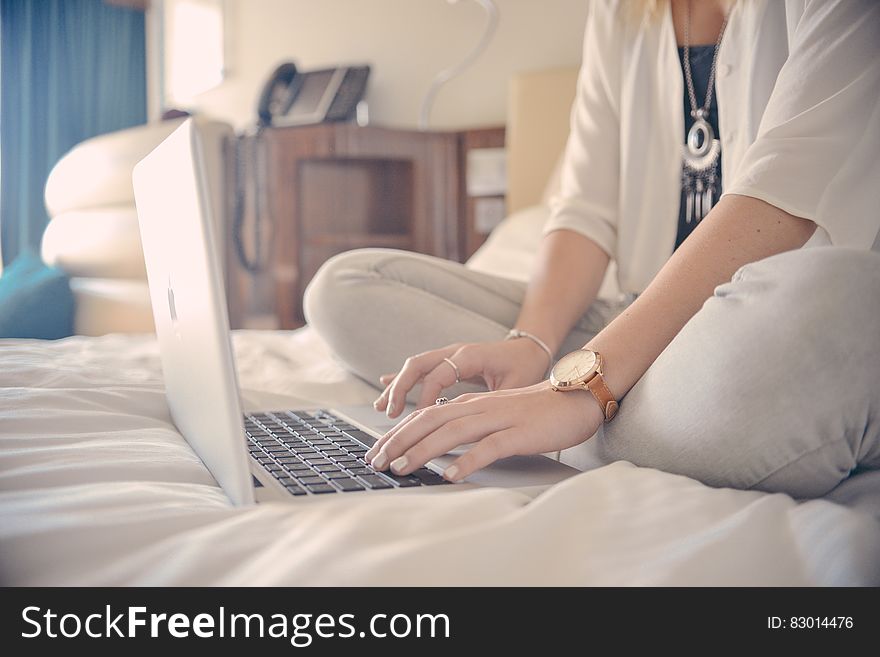 Woman Sitting On Bed With Computer