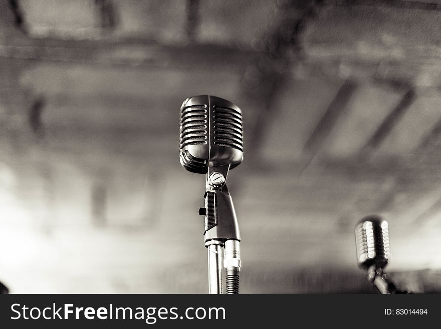 Vintage microphones on stand in black and white.