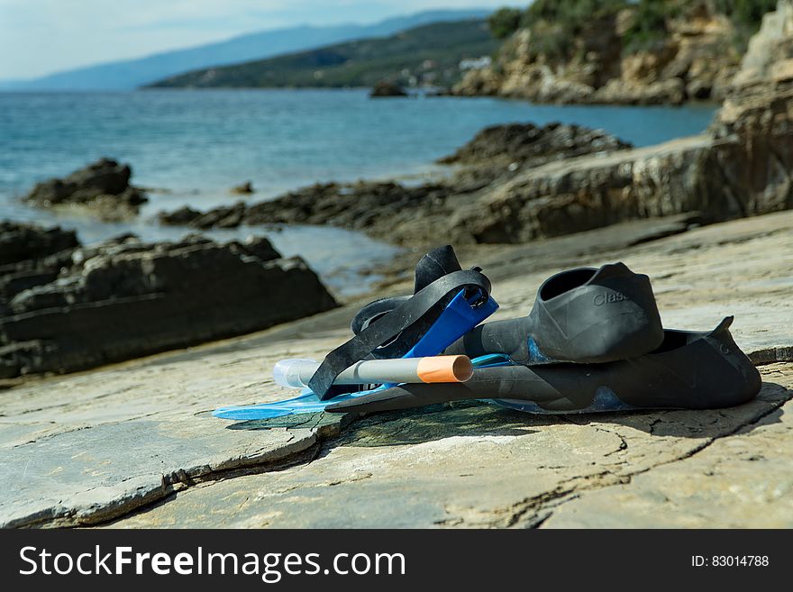 Black Rubber Flipper On Gray Concrete Surface During Daytime