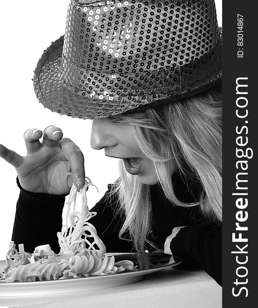 Woman in Sweater and Sequin Fedora Hat Holding Noodles in Grayscale Photography