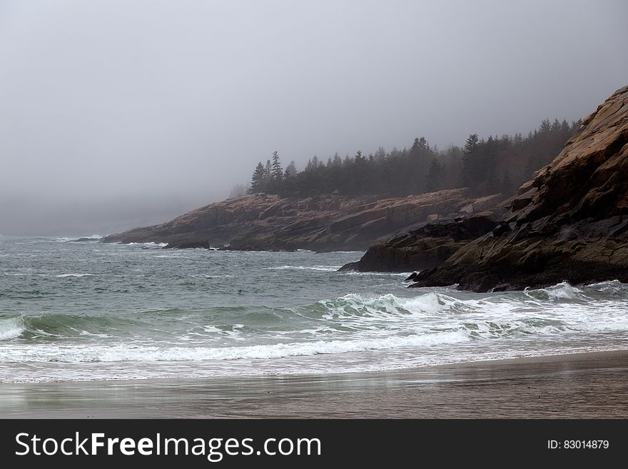 Mountain Surrounding Bodies Of Water Cloudy Skies During Daytime