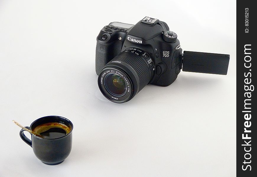 Black Canon Dslr Camera in Front of Coffee in Black Ceramic Teacup