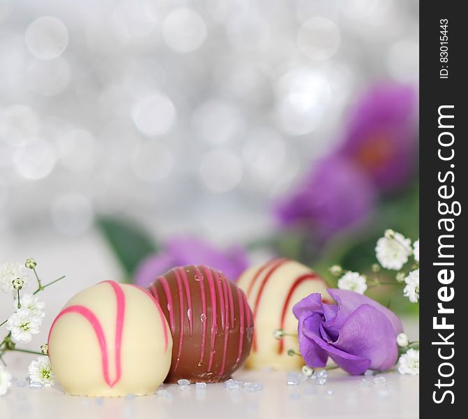 White and Chocolate Sweets With Purple Petal Flower Photo