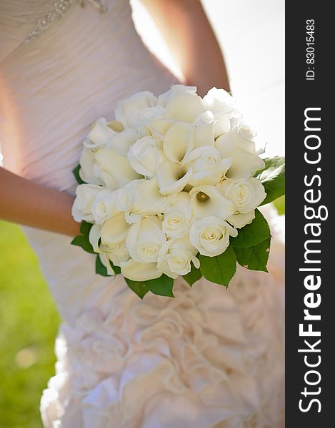 Woman in Wedding Dress Holding White Flower Bouquet