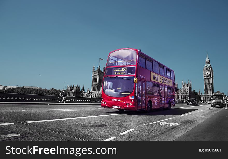 Double decker bus on roadway outside Parliament Building with Big Ben clock tower in London, England. Double decker bus on roadway outside Parliament Building with Big Ben clock tower in London, England.