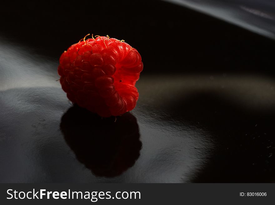 Closeup of red fresh raspberry fruit on a dark surface with reflection. Closeup of red fresh raspberry fruit on a dark surface with reflection.