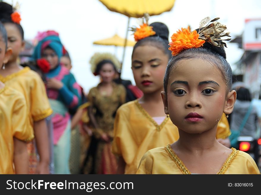 A group of Asian children,beautifully dressed, most in gold, with selective focus on one small charming young girl wearing flowers to decorate her hair. A group of Asian children,beautifully dressed, most in gold, with selective focus on one small charming young girl wearing flowers to decorate her hair.