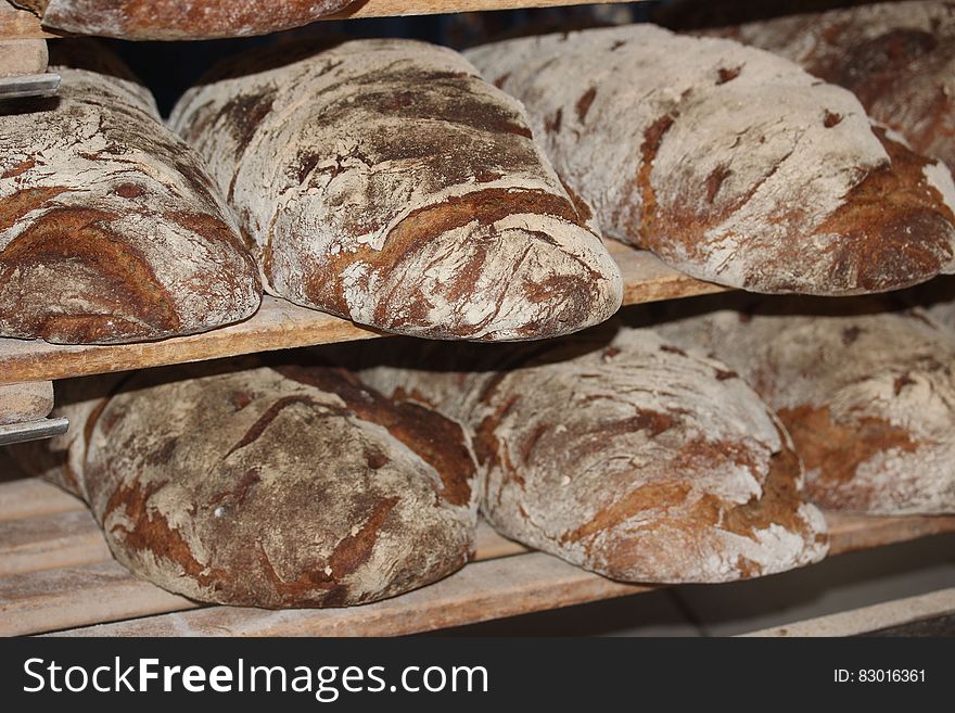 Loaves of bread on racks in a bakery.