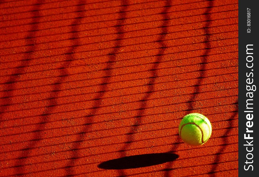 Green Tennis Ball on Red Floor during Sunny Day