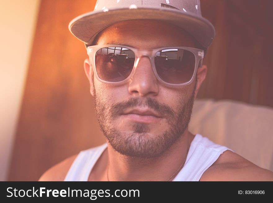 Closeup portrait of man in hard hat and white vest with beard and moustache and dark glasses, possibly African American construction worker. Closeup portrait of man in hard hat and white vest with beard and moustache and dark glasses, possibly African American construction worker.