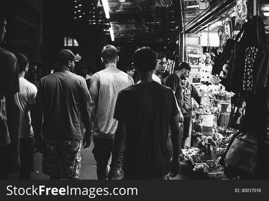 Group of men walking down urban street at night in black and white. Group of men walking down urban street at night in black and white.