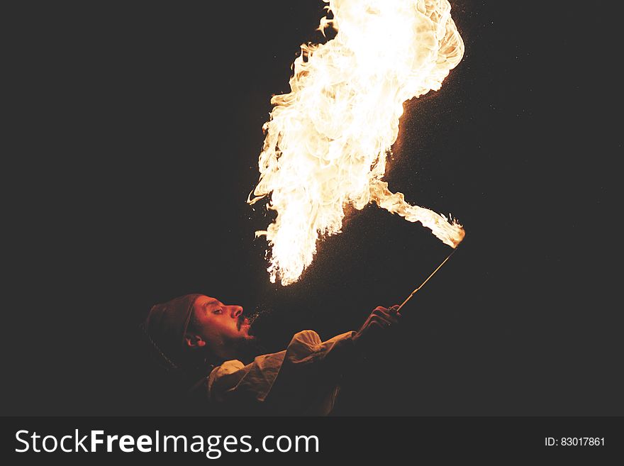Man Blowing Fire during Nighttime
