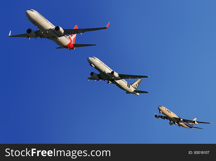Commercial airplanes flying in formation in blue skies. Commercial airplanes flying in formation in blue skies.