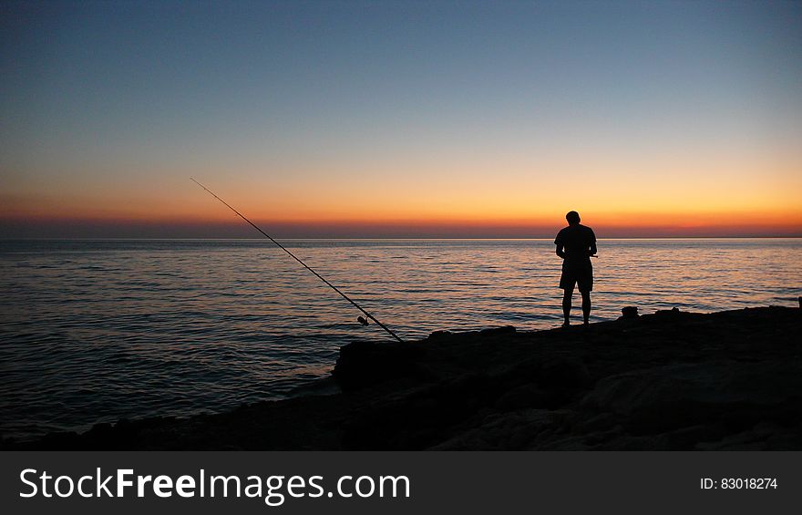 Person Fishing During Sunset